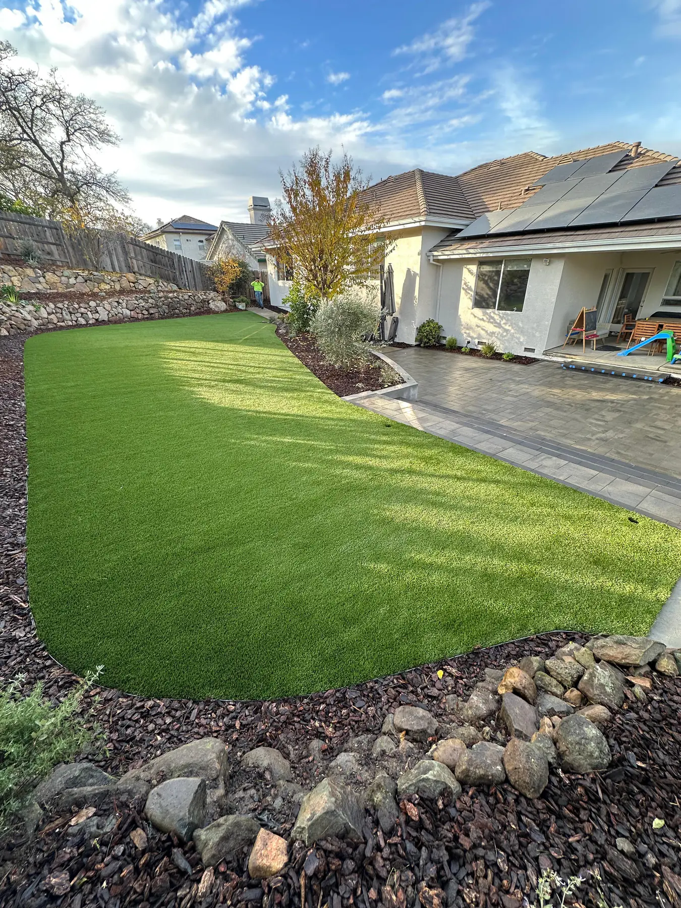 Green artificial turf beside a residential walkway