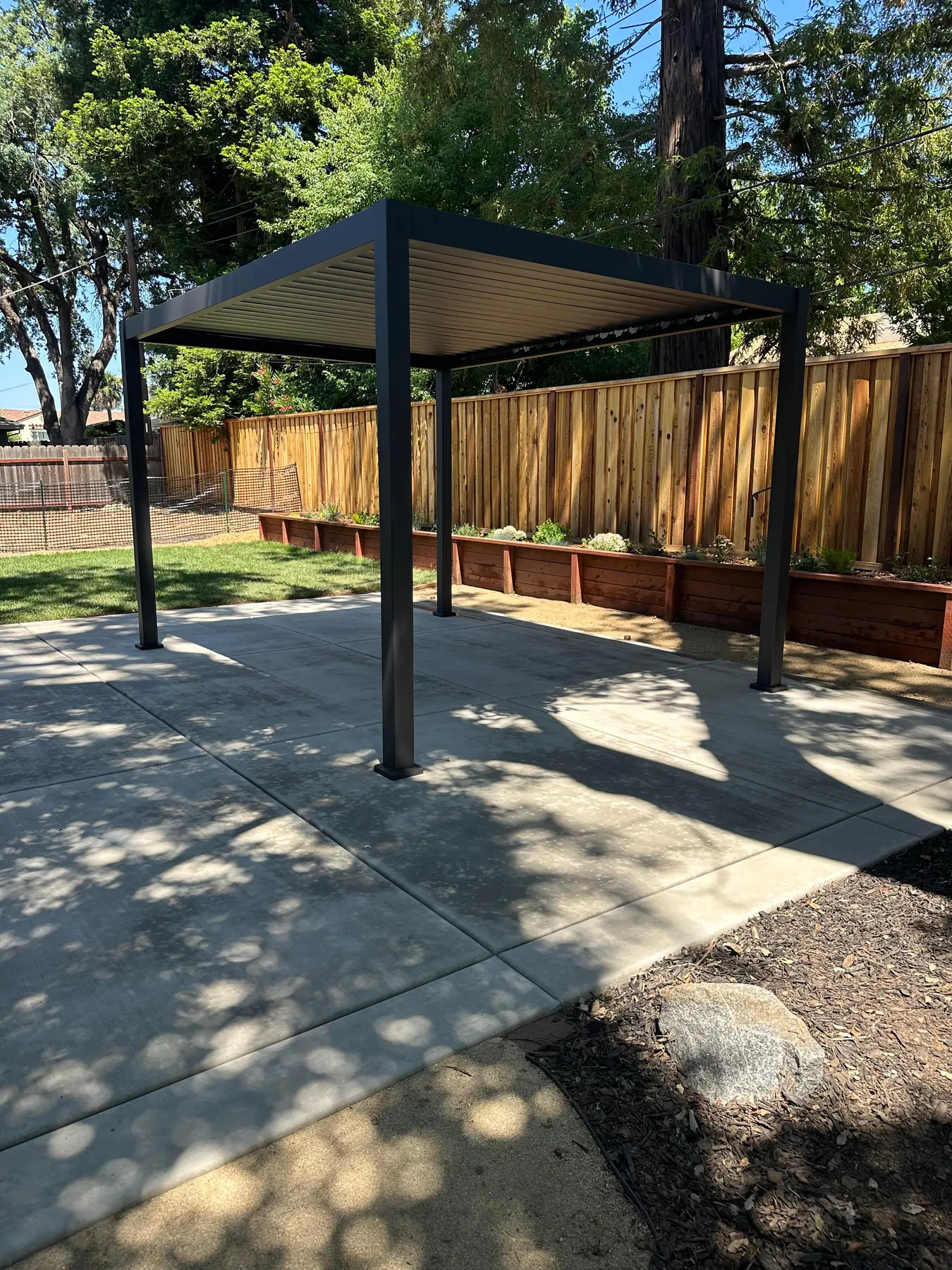 Concrete patio surface with posts and gravel border