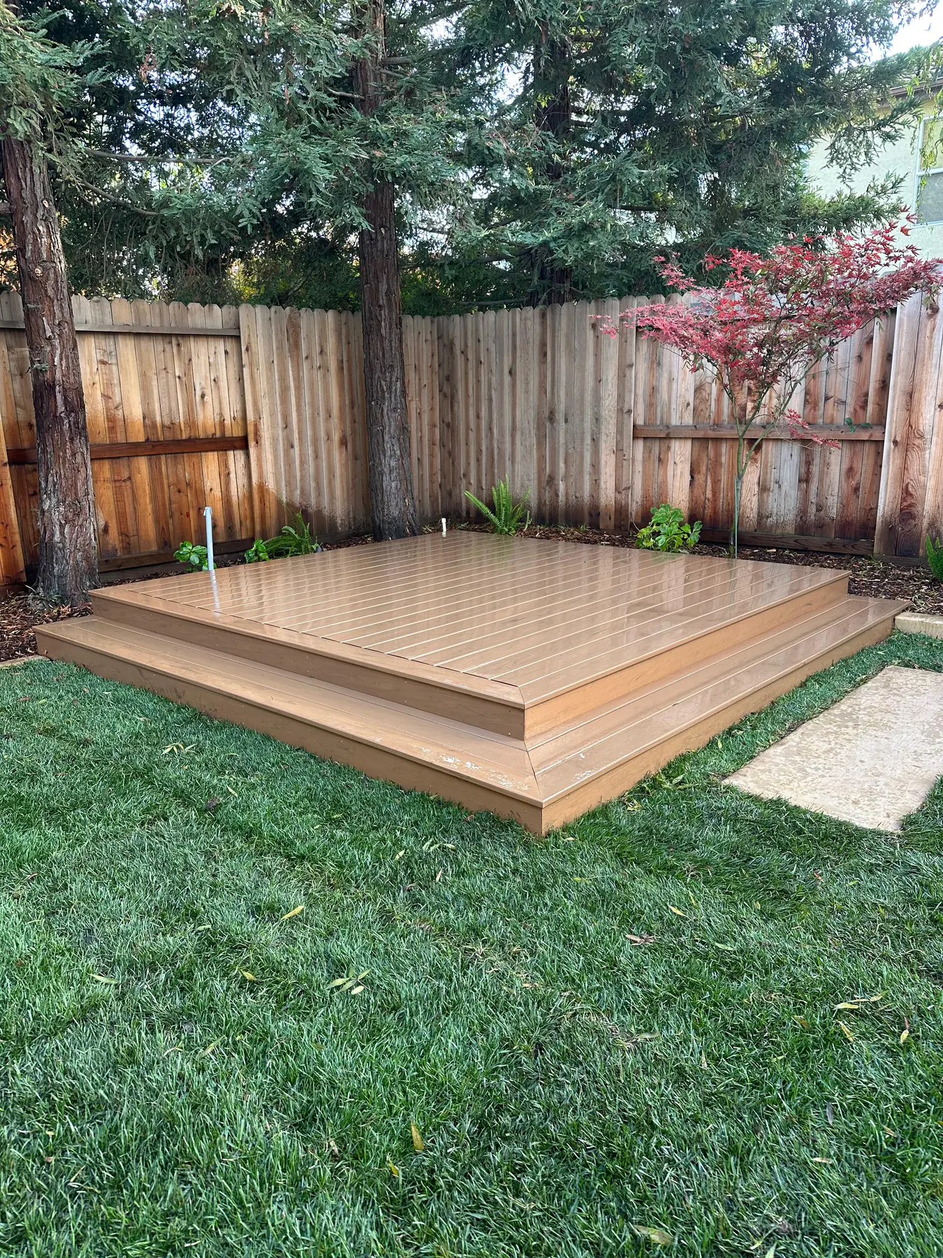 Small wood deck patio beside a fence