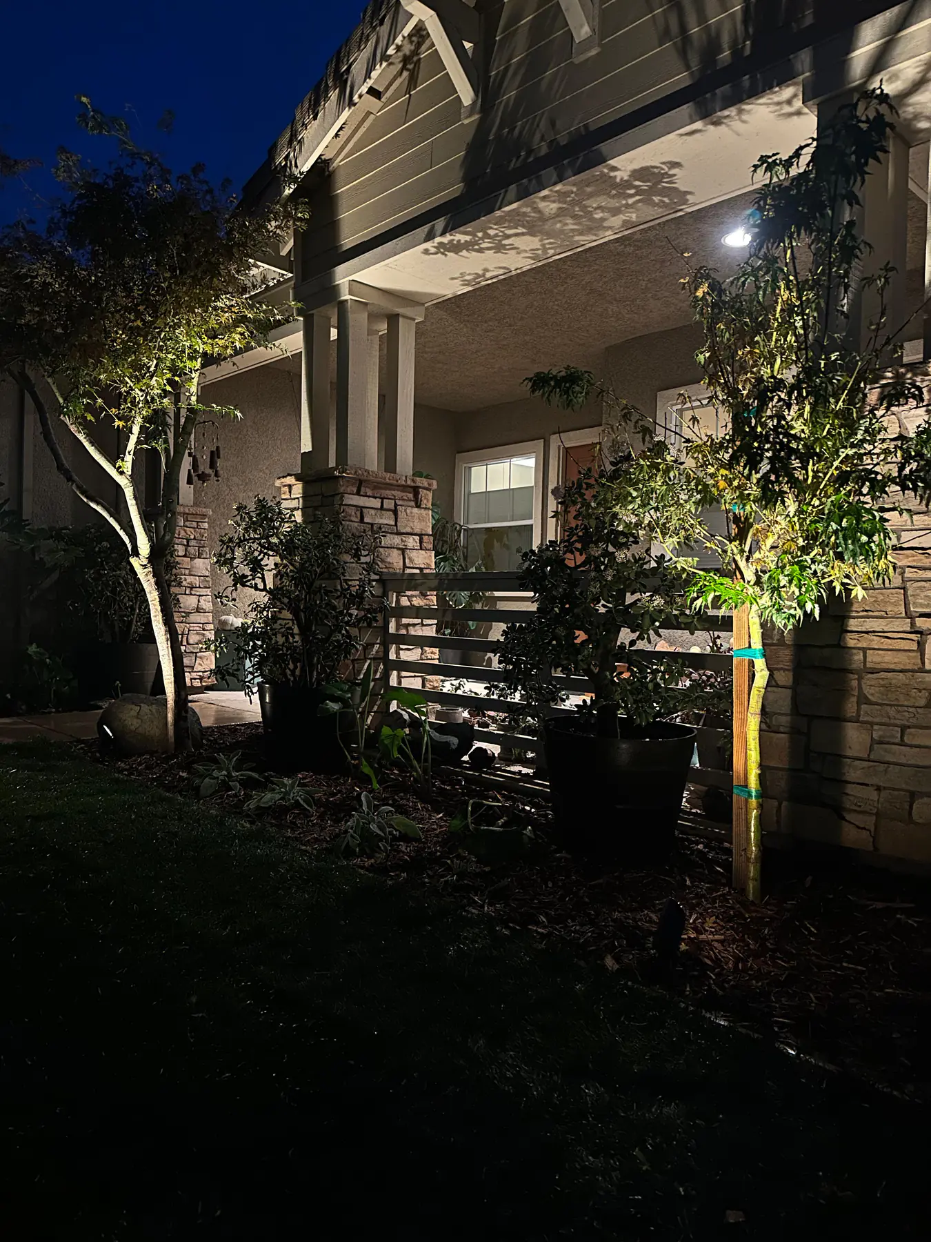 Home facade with landscape lighting near entry