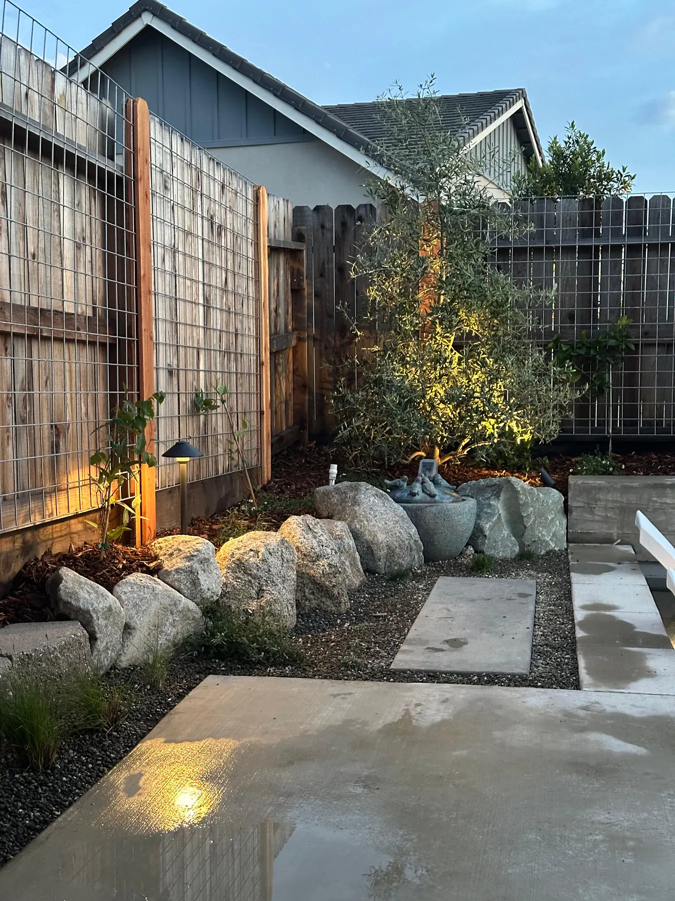 Boulders, gravel, path slabs, and a decorative water pot