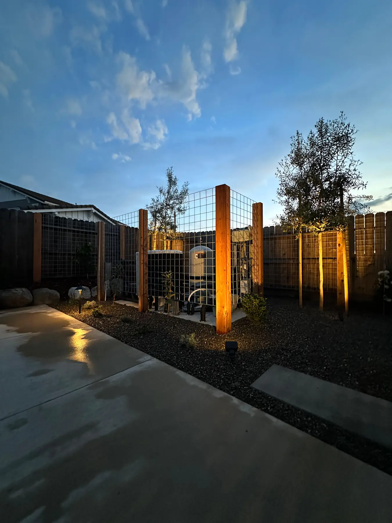 Modern wood and wire fence with landscape lighting