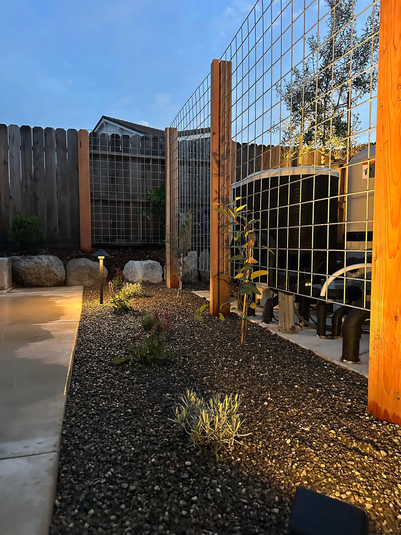 Wood and wire fence gate detail with planting