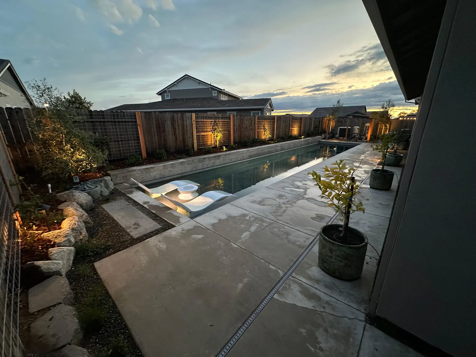 Wide pool patio overview with modern fence and planting