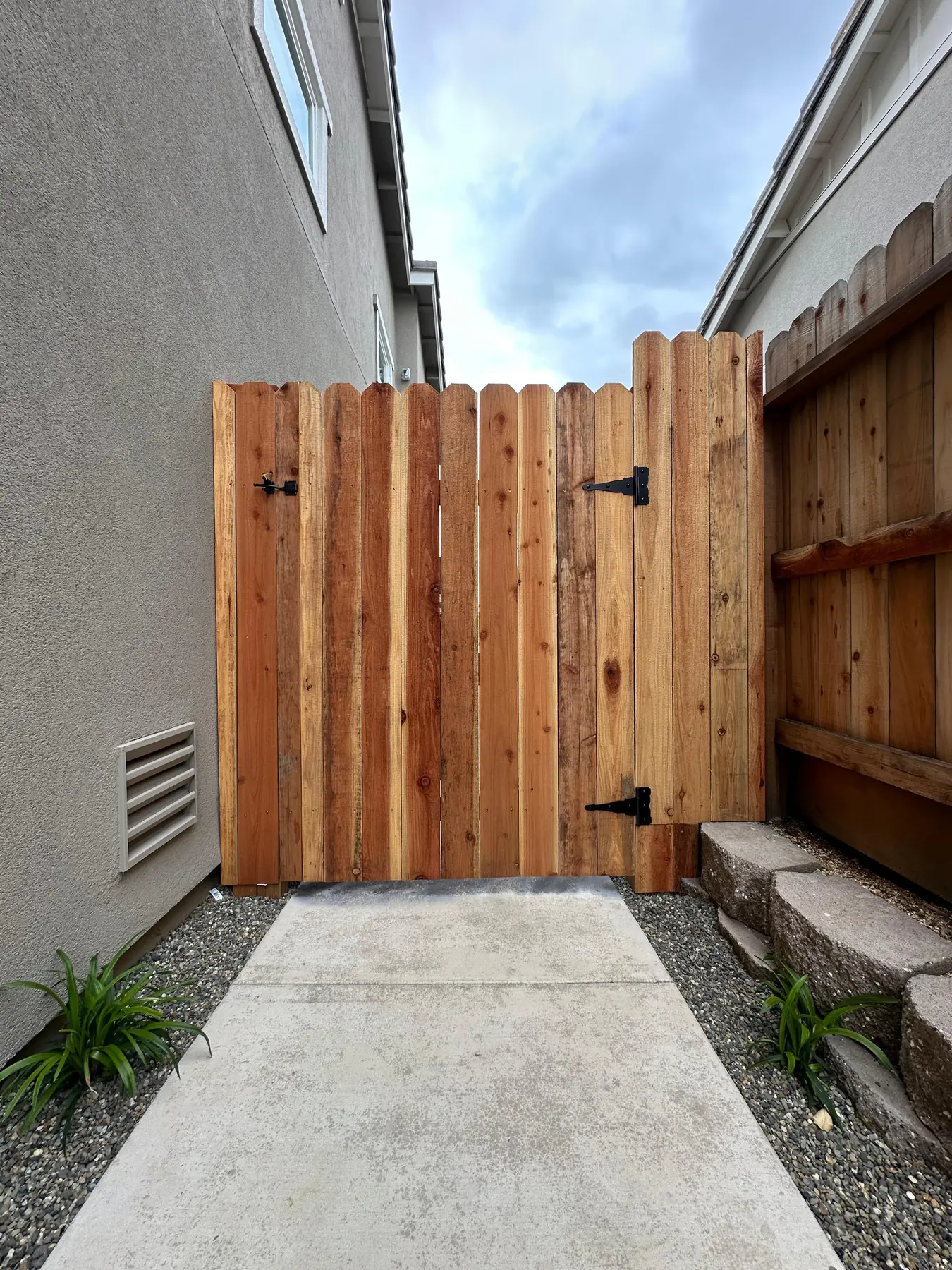 Wood gate at the end of a side yard path